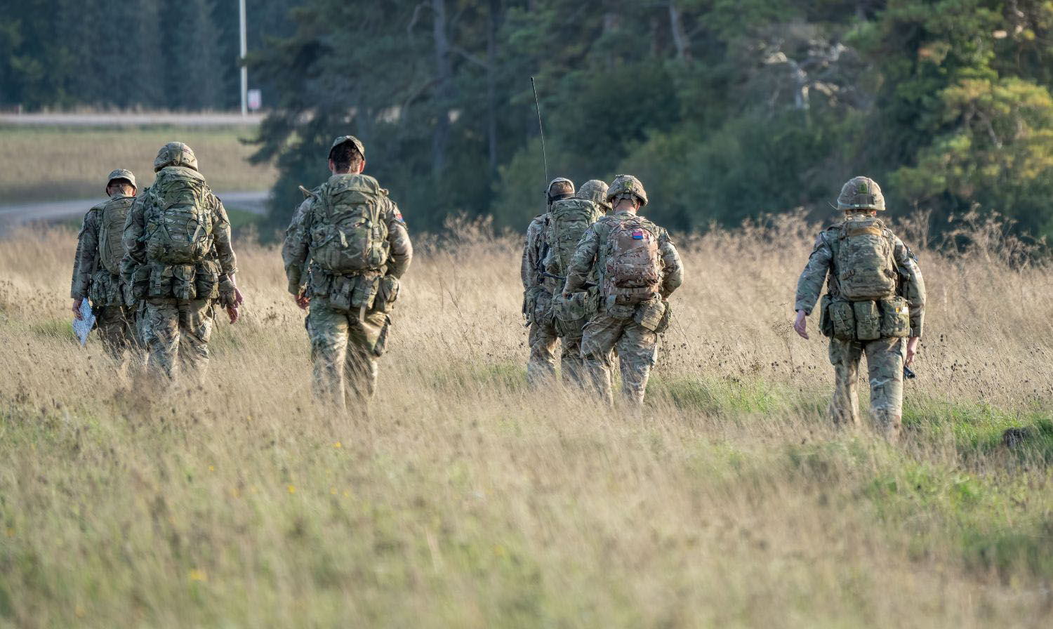 Army soldiers tabbing with 25Kg bergens across open countryside