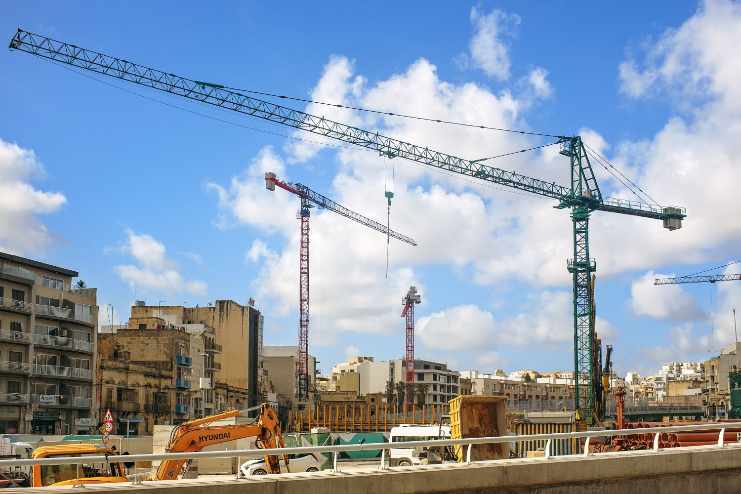 Heavy machinery and tower cranes working on a large scale urban development project
