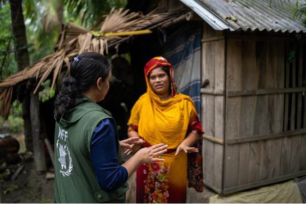 A WFP staffer speaks to a woman. WFP/Mehedi Rahman