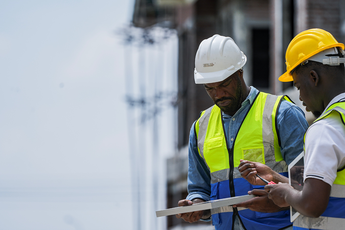 An experienced engineer teaches an apprentice about solar panel installation on a construction site