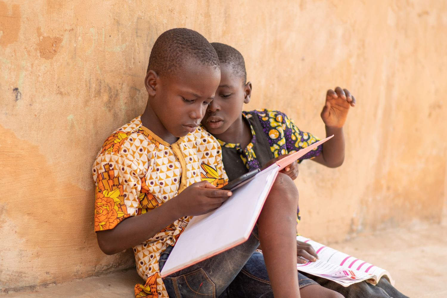 Two male students doing homework with a phone
