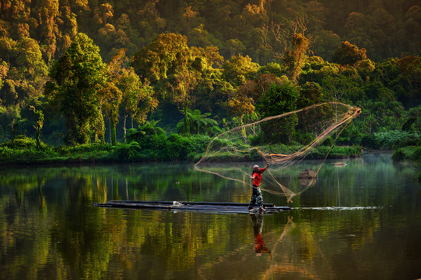 Situ Gunung, Sukabumi, West Java, Indonesia. Man fishing in the lake using a traditional net.