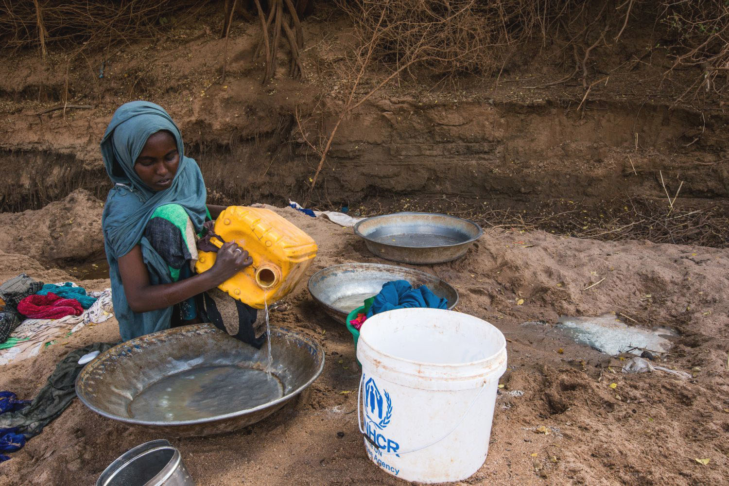 A woman in Somalia washing clothes with river water