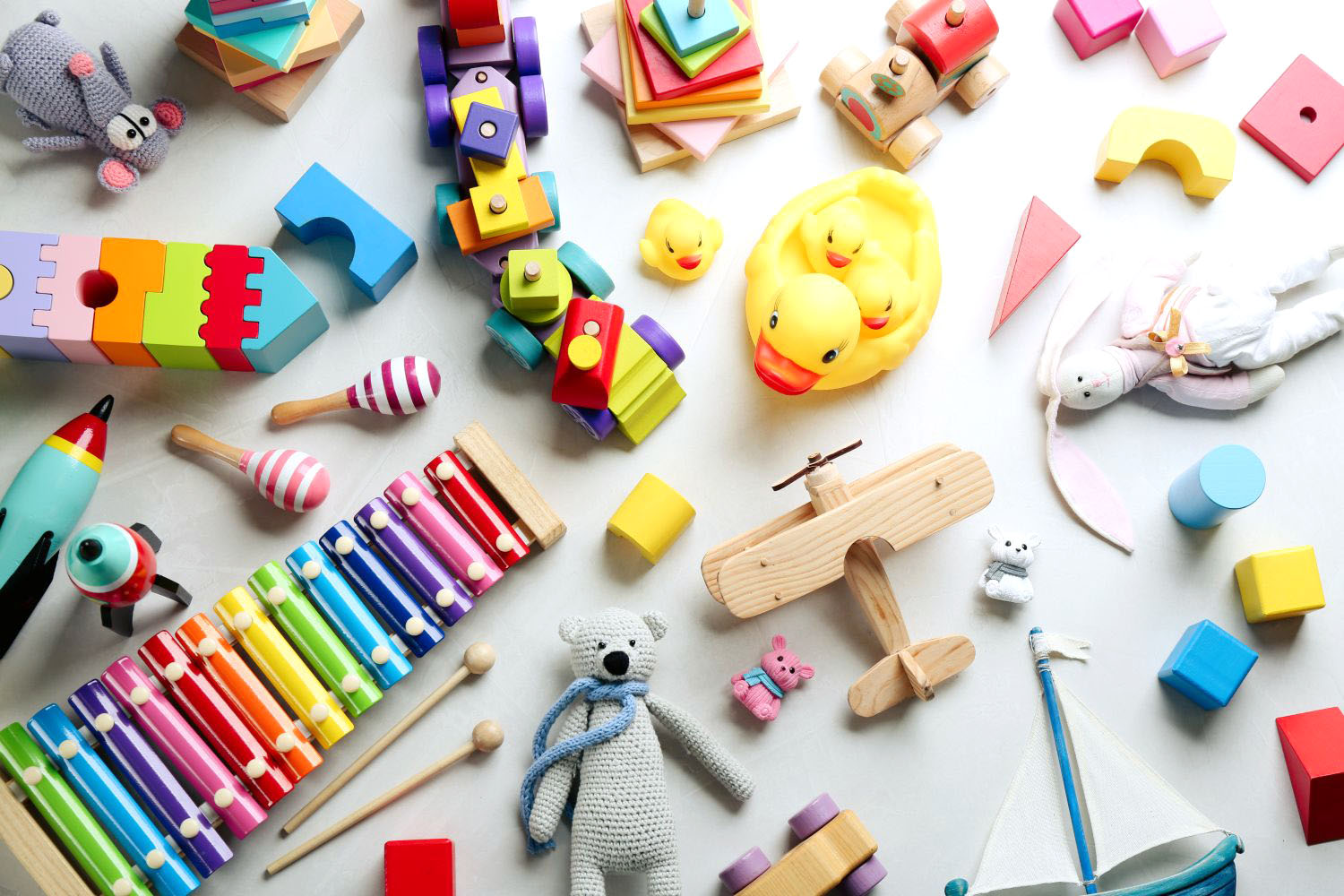 Different toys on light background, flat lay