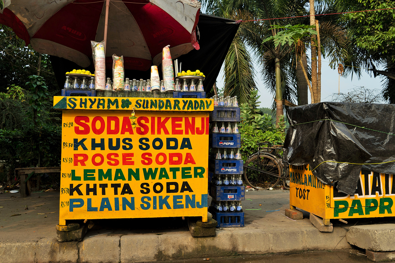Soda vendor stall with poster stating soda options