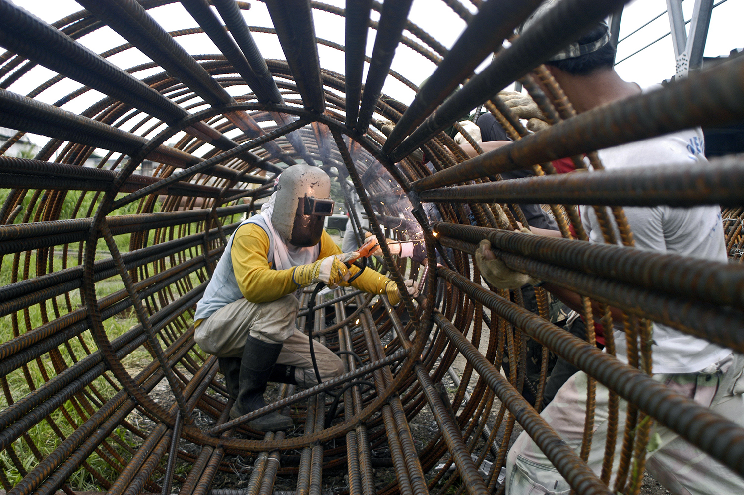 Man working inside a large reinforced steel tube. Philippines