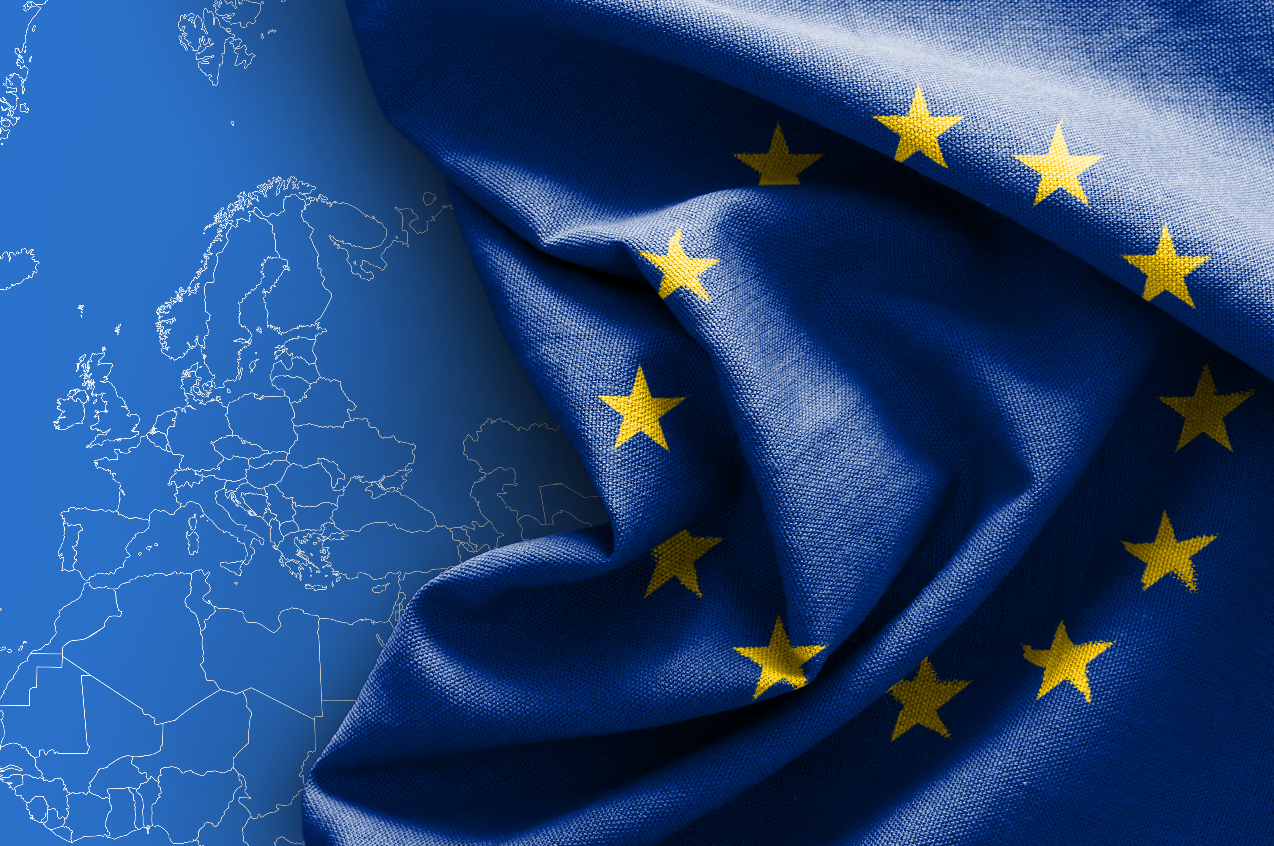 European Union flags flutter in the breeze against a backdrop of modern buildings