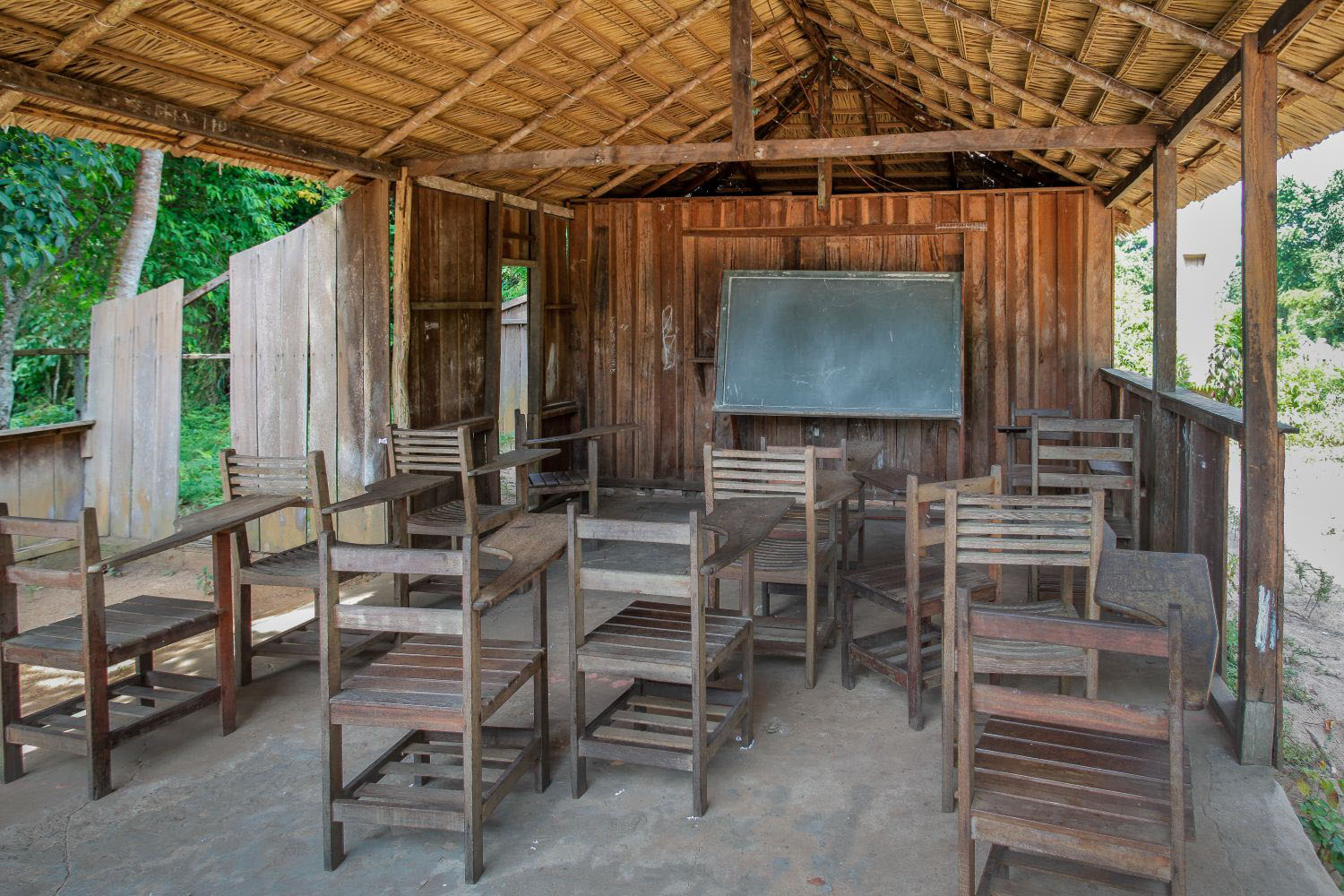Image of a rural chool made of wood with a straw roof 