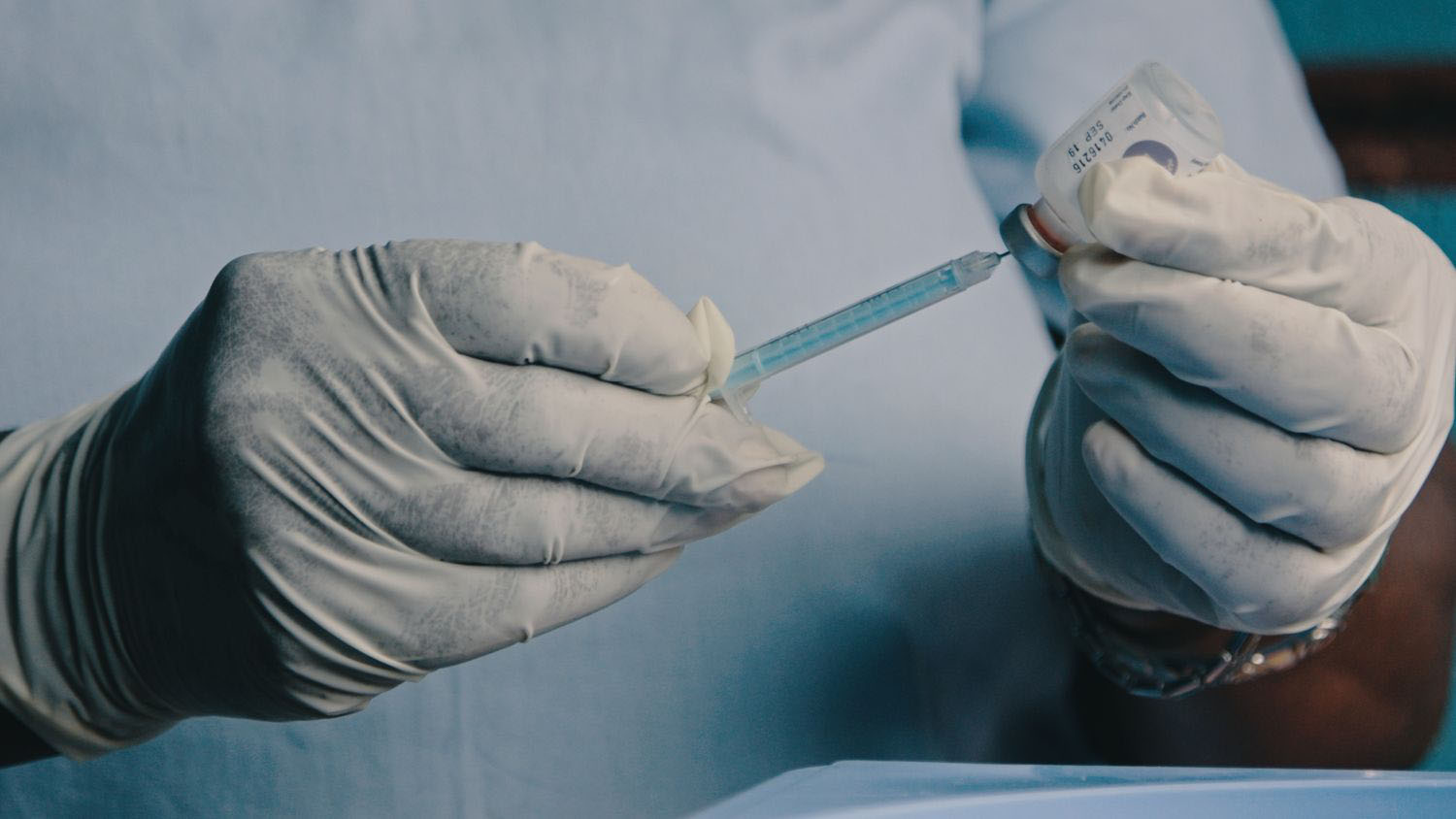  Local medical nurse preparing a vaccination to be injected with a needle and syringe