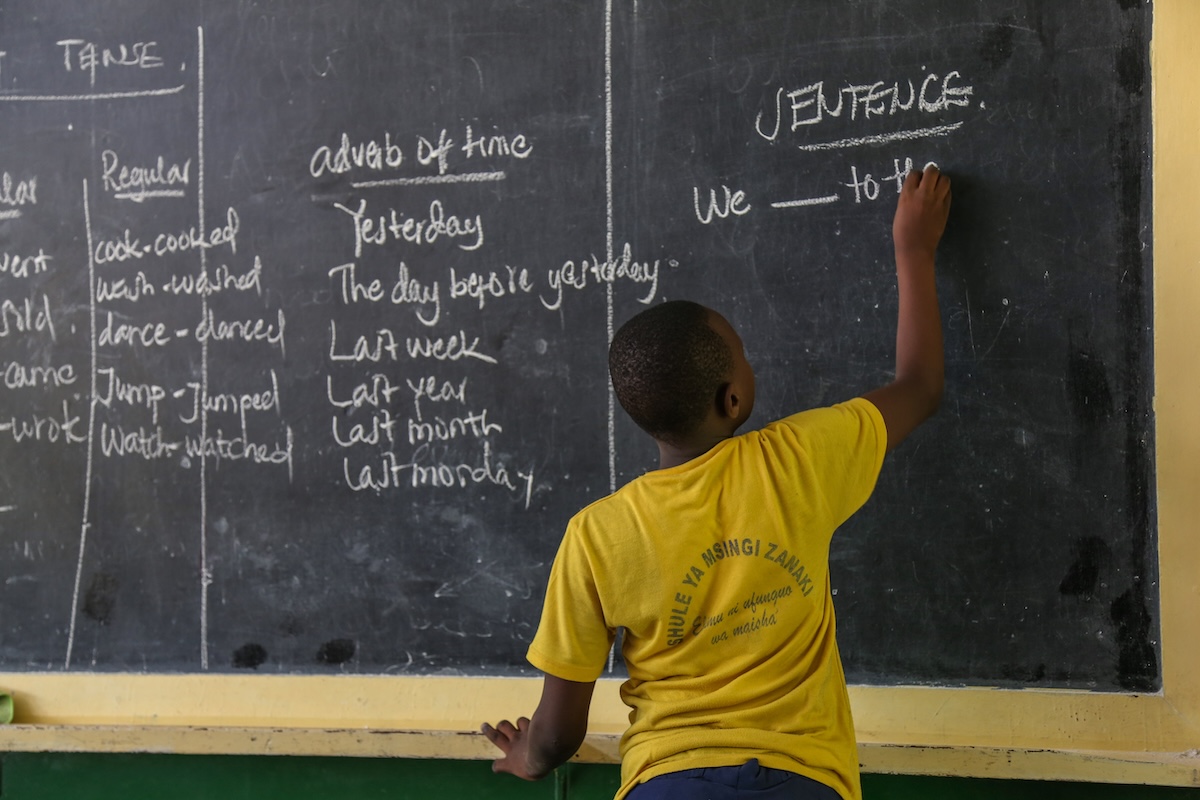 A student at a black board in Dar es Salaam, Tanzania