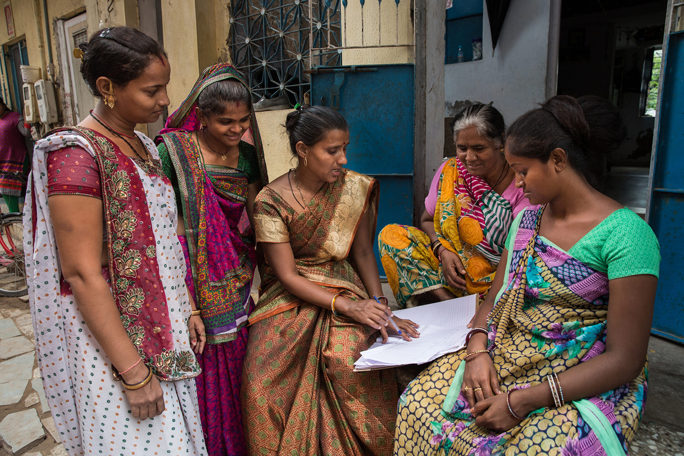 Neighbourhood women gather outside their homes to discuss the area upkeep and work issues, Ahmedabad, Gujarat, India