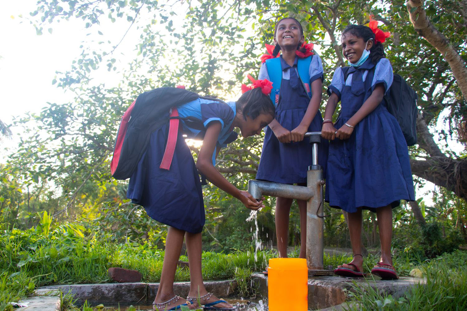 School children drinking water from a well 
