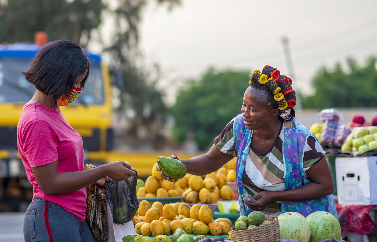 Woman buying fresh produce from a farmer on the roadside.