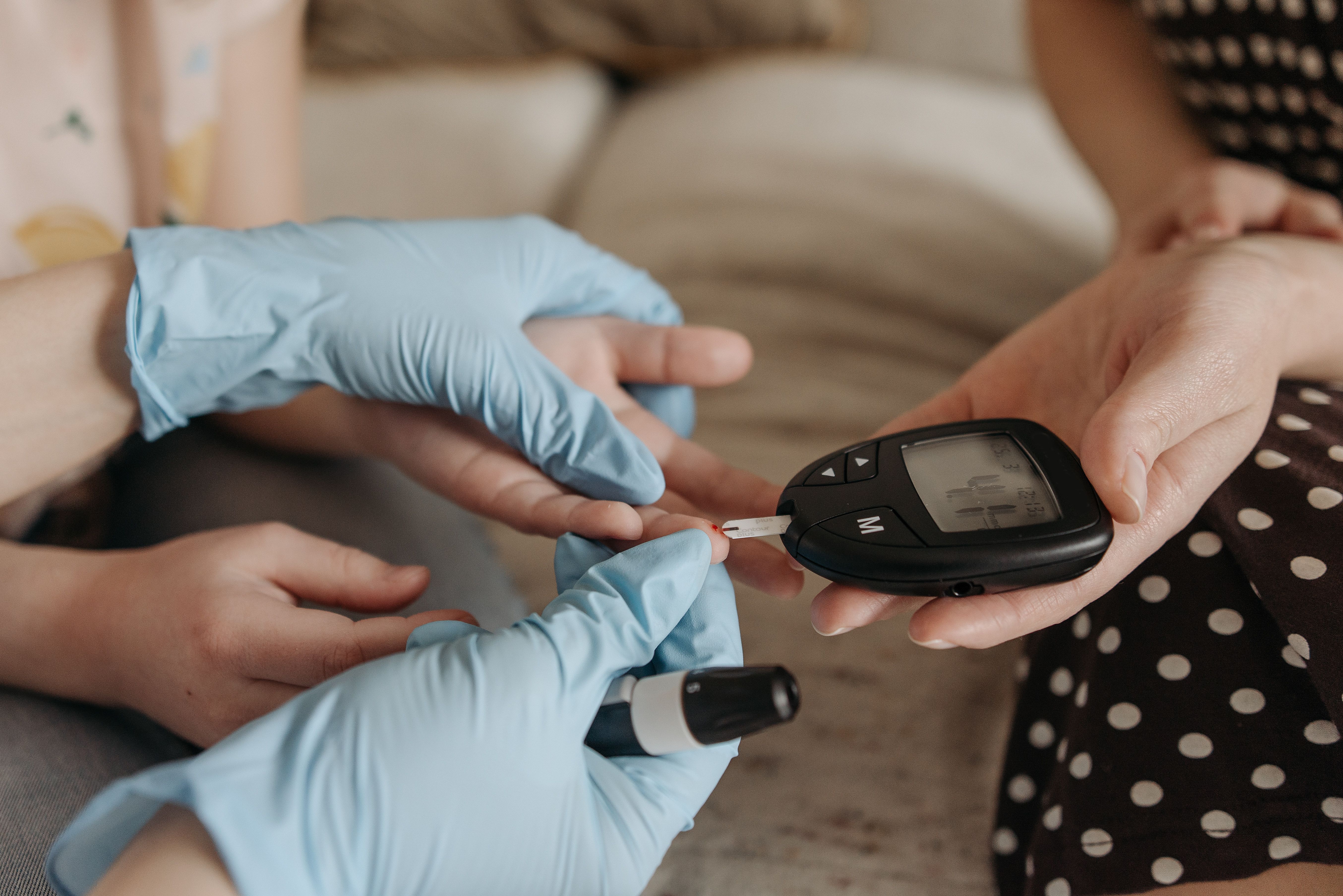 Hands of medical operator conducting a fingerprick blood test