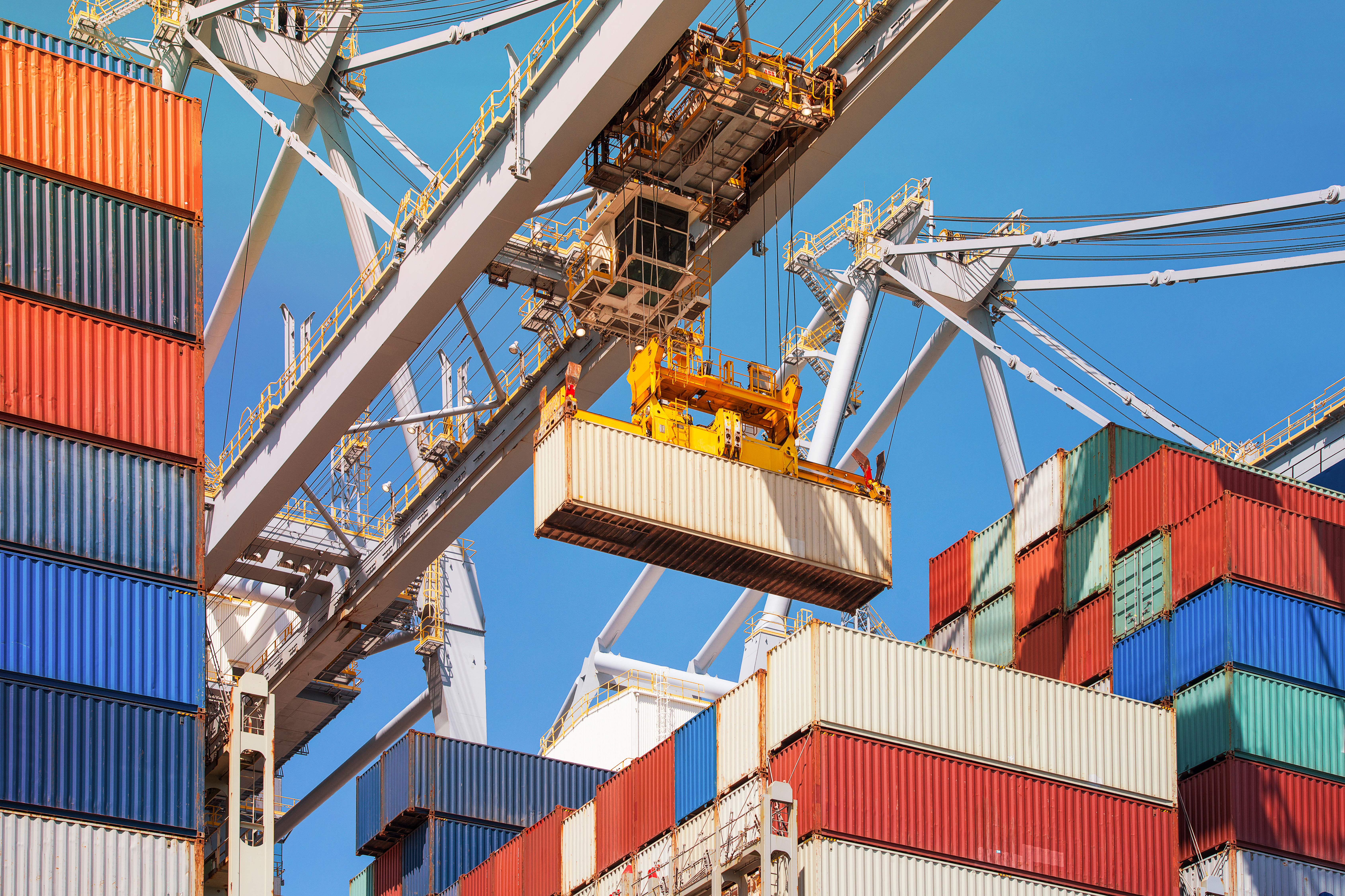 A crane lifts shipping crates at a port 
