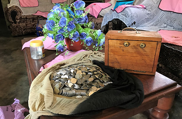 wooden lockbox and pile of coins in Tanzania