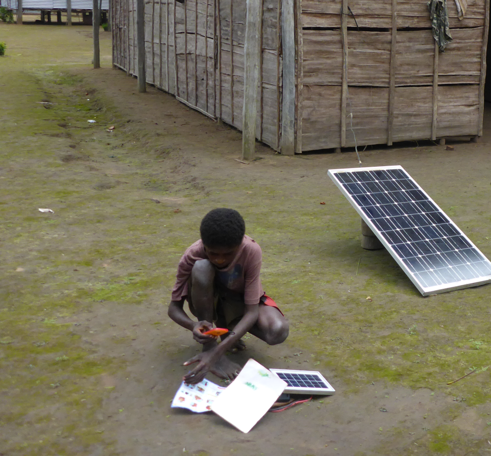 boy charging phone with solar power