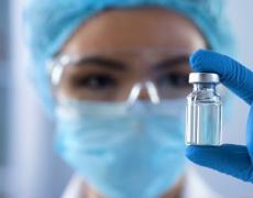 An image of a doctor holding a vaccine. 