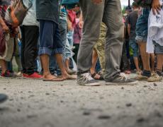 The feet of Honduran migrants waiting in line 
